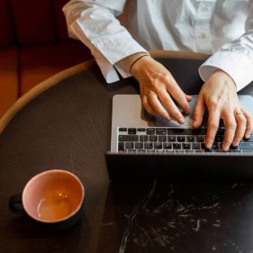 Person using laptop with cup of coffee